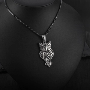 Detailed view of Celtic knot owl pendant in retro silver finish on a black display stand