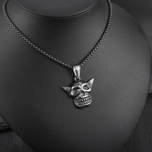 Detailed view of stainless steel skull pendant with wings on a vintage round box chain