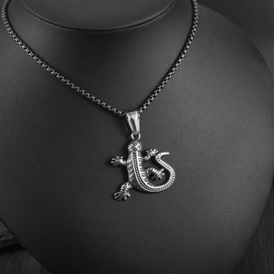 Detailed view of silver gecko lizard pendant with tribal texture on a black neck bust
