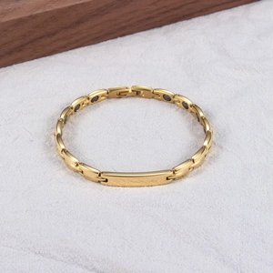 Détail du bracelet en acier inoxydable doré avec inserts magnétiques et plaque en métal