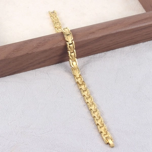 Elegante bracciale a maglie dorate a forma di trofeo con chiusura magnetica su fondo grigio