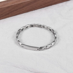 Gros plan du bracelet de magnétothérapie en acier inoxydable argenté avec aimants noirs