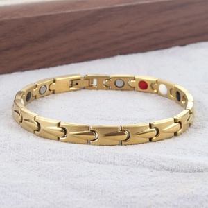 Detail eines mattgoldenen Magnettherapie-Armbands mit Funktionssteinen und Klappverschluss