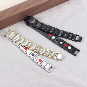 Magnetic therapy bracelets in black, gold, and silver on grey textured linen background