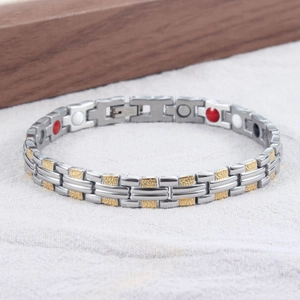 Detailansicht eines Magnettherapie-Armbands mit goldenen Gliedern und inneren Funktionssteinen
