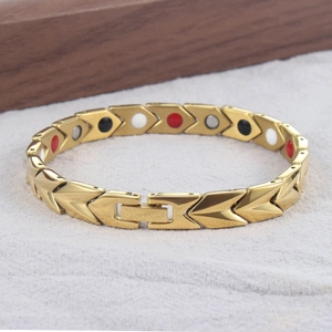 Vue détaillée du bracelet magnétique doré à maillons flèches et pierres d'énergie