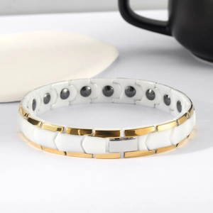 Vue détaillée d'un bracelet magnétique doré avec maillons en céramique blanche et fermoir