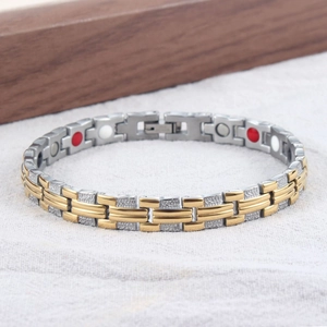 Nahaufnahme des Magnettherapie-Armbands mit gold-silbernen Gliedern aus Edelstahl