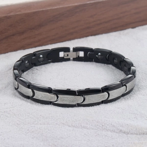 Detail eines magnetischen Gliederkettenarmbands mit schwarzen und silbernen Keramikeinsätzen