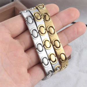 Detailweergave van zilveren en gouden ovale magnetische armbanden voor mode en welzijn