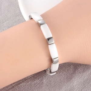 Dettaglio del bracciale magnetico in ceramica bianca e acciaio con maglie a bambù
