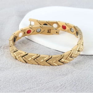 Golden magnetic therapy bracelet with weave texture and four-color stones on white plate