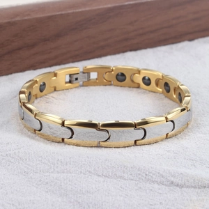 Detail eines kugelförmigen Magnetarmbands mit gold- und silberfarbenen Gliedern