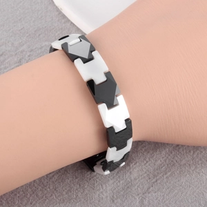 Detailed view of black and white ceramic geometric link bracelet with folding metal clasp