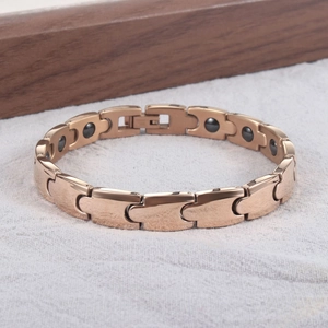Detailansicht eines roségoldenen Magnetarmbands mit kreisförmigen Magneten auf der Innenseite
