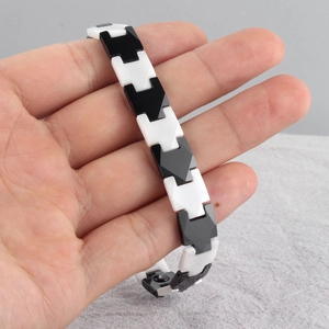 Detail of black and white ceramic bracelet links with secure metal folding clasp