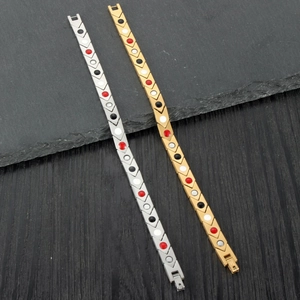 Detailed macro of gold and silver magnetic arrow link bracelets with embedded therapy magnets