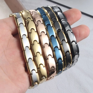 Nahaufnahme von magnetischen Gliederarmbändern in verschiedenen Metallic-Farben am Handgelenk