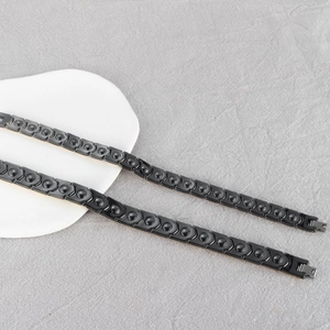 Macro detail of black magnetic therapy bracelet with arrow links and metal folding clasp