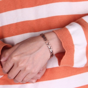 Magnetisches Kupferarmband im Vintage-Stil mit S-Gliedern am Handgelenk eines Models