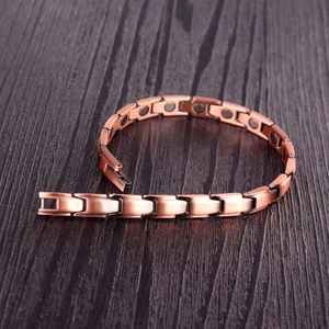 Bracelet magnétique rétro en cuivre pour femmes sur fond de bois sombre et lisse