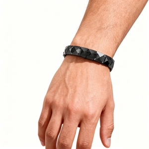Close-up of a men's black geometric ceramic bracelet with magnetic facets on wrist