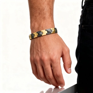 Macro detail of men's ceramic bracelet with black and gold geometric pyramid links