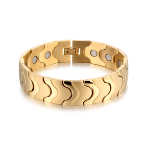 Detail of wide gold magnetic therapy bracelet with wavy links and stainless steel engraving