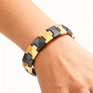 Close-up of geometric ceramic and gold plated links on a magnetic therapy bracelet