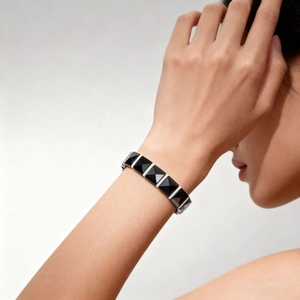 Detail of magnetic ceramic bracelet featuring black pyramid facets and silver metal finish