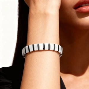 Detail of minimalist black and white ceramic magnetic bracelet on person's wrist