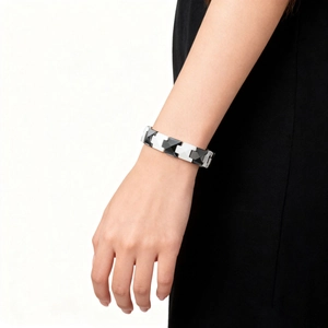Close-up of minimalist black and silver ceramic diamond geometric magnetic bracelet on wrist