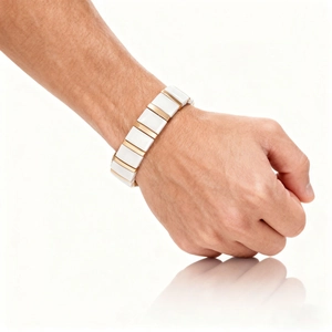 Close-up of modern white ceramic bracelet with gold metal links on man's wrist