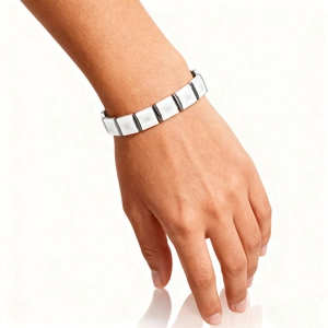 Detail of silver metallic bracelet with geometric diamond-cut ceramic facets on wrist