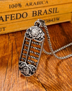 Macro shot of silver abacus pendant with Fu character on rustic wood background