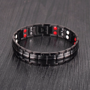 Detailed macro view of black stainless steel link bracelet with red and white magnets