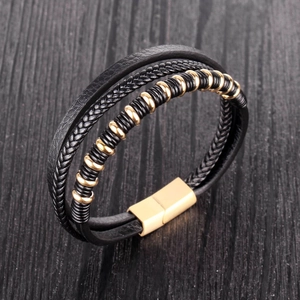 Close-up of multilayer black leather braided bracelet with polished gold magnetic clasp