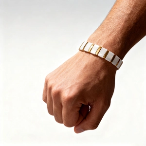 Close-up of modern ceramic bracelet with gold metal accents on a wrist