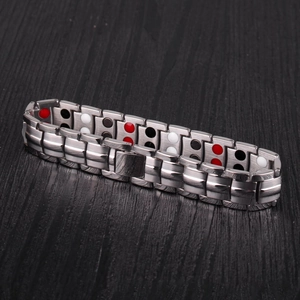 Macro detail of men's stainless steel magnetic bracelet with tri-color health stones