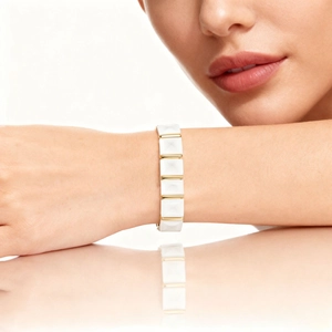 Macro shot of a ceramic geometric bracelet with white diamond-cut beads and gold accents