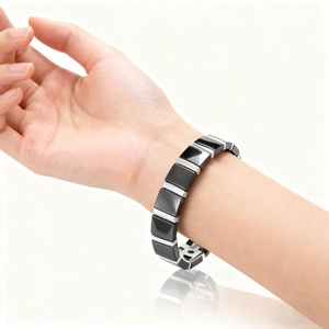 Unisex black ceramic and silver magnetic bracelet shown on wrist with elegant reflections