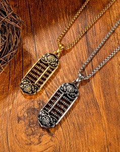 Detailed view of gold and vintage silver abacus pendants with Fu character on wood