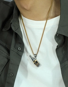 Gros plan d'un collier pour homme avec pendentif bouteille tête de mort porté par un modèle