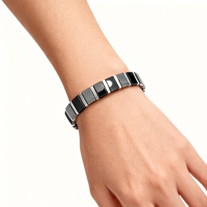 Close-up of minimalist black ceramic and silver metal magnetic bracelet on wrist