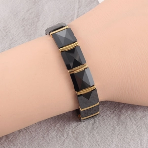 Close-up of trendy magnetic bracelet featuring black ceramic diamond facets on a wrist