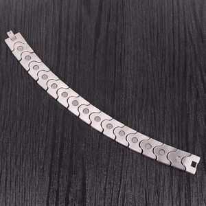 Macro detail of men's stainless steel energy bracelet showing grey magnetic therapy stones