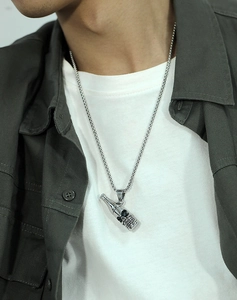 Détail du pendentif bouteille tête de mort sur chaîne carrée pour homme style punk