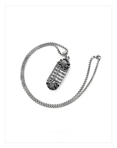 Macro shot of retro abacus pendant with ruyi pattern and vintage steel chain
