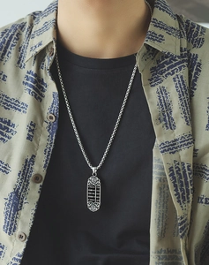 Close-up of a men's steel necklace featuring an abacus and Fu character pendant