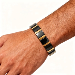 Detail of trendy black ceramic and gold metal magnetic bracelet worn on male wrist